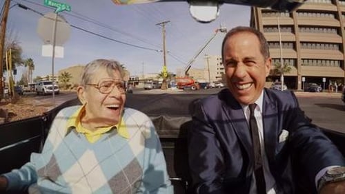 Two men in a convertible laughing