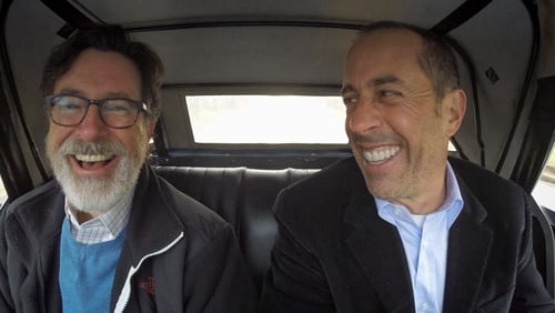 Two men sitting in a car laughing