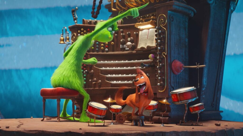 Animated green creature sitting at an organ with a dog at his feet playing the drums
