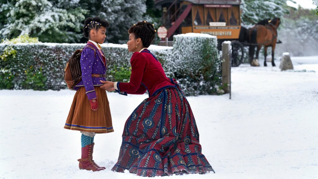 A woman and a young girl standing in the snow