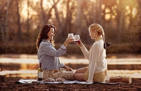Two women having a picnic beside a lake