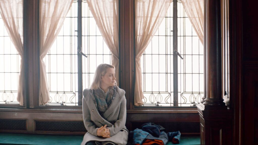 A woman sitting alone by a window