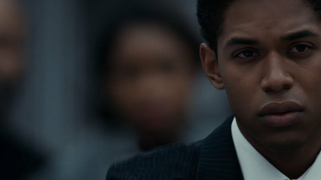 a black teen boy in a suit in a courtroom