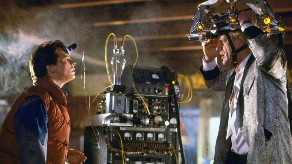 Two men, standing facing each other, both with gadgets on their heads